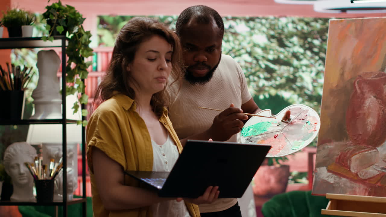 Artists collaborating on a painting in their studio