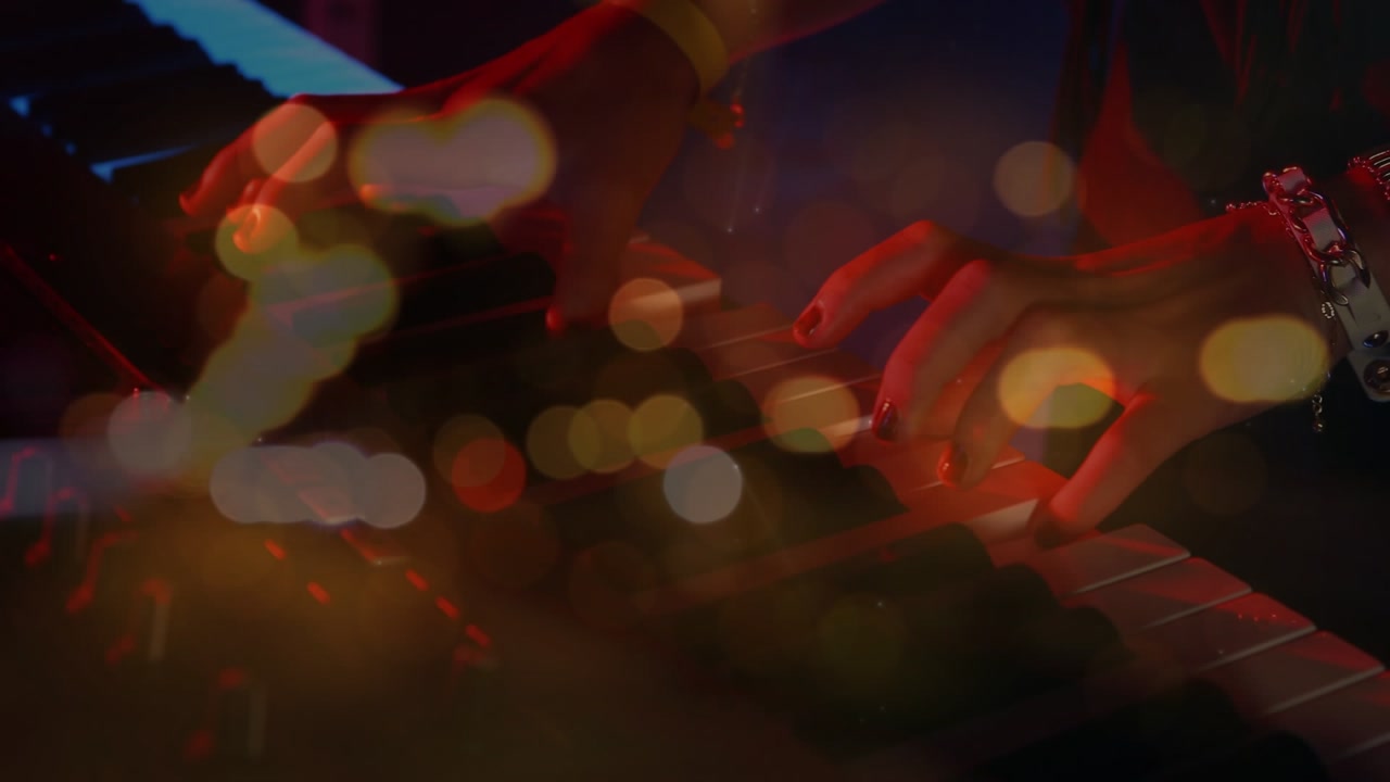 Animation of blurred night road traffic over hands of caucasian man playing keyboard on concert