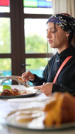 mujer comiendo cena de pollo en un restaurante