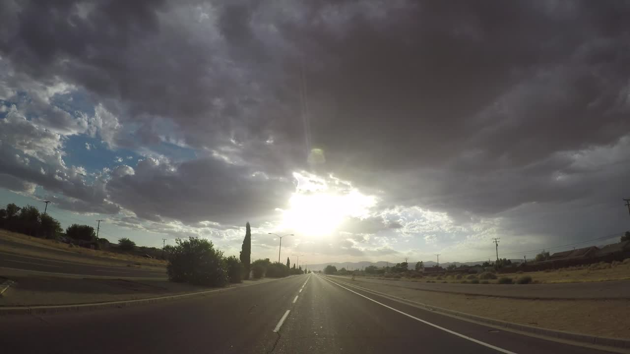 Timelapse mentre si guida verso il sole del mattino con nuvole temporalesche sopra in California