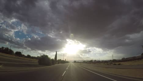 timelapse driving towards morning sun with storm clouds above in california