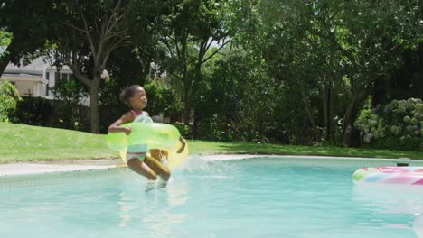 Happy-african-american-sibling-jumping-into-pool-with-inflatable-wheels