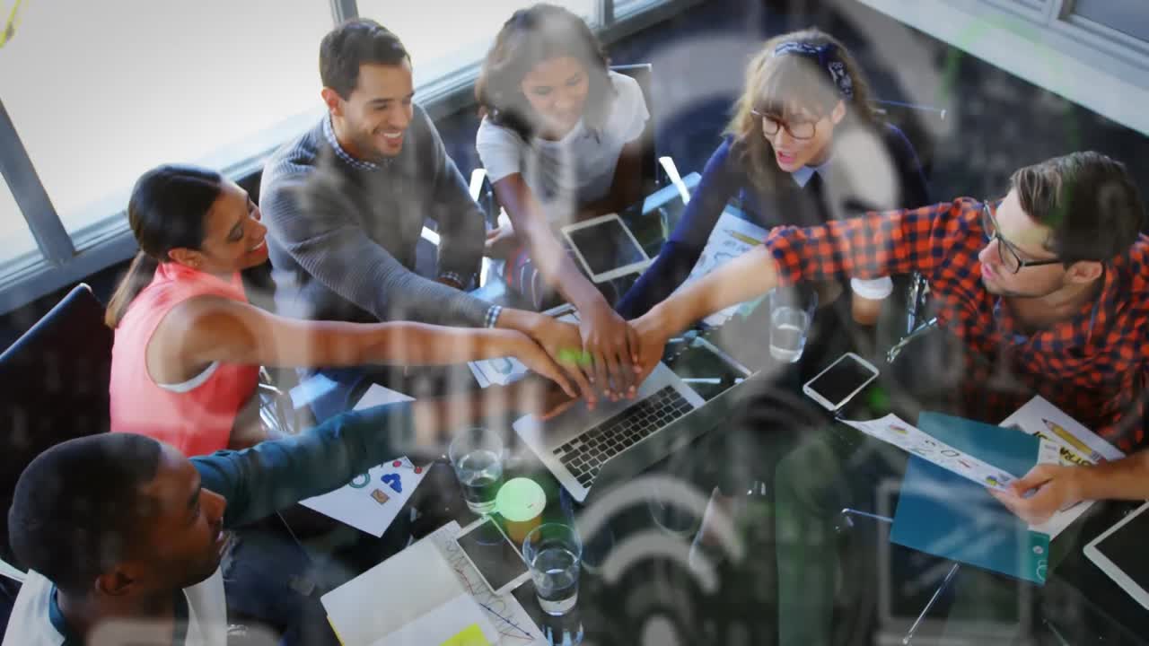 iconos digitales contra colegas de oficina apilando las manos juntos