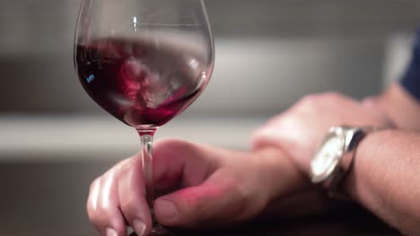 male hand aerating a glass of red wine