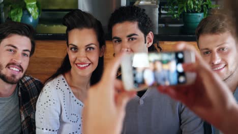 Mujer-Haciendo-Clic-En-La-Foto-De-Amigos-En-El-Teléfono-Móvil