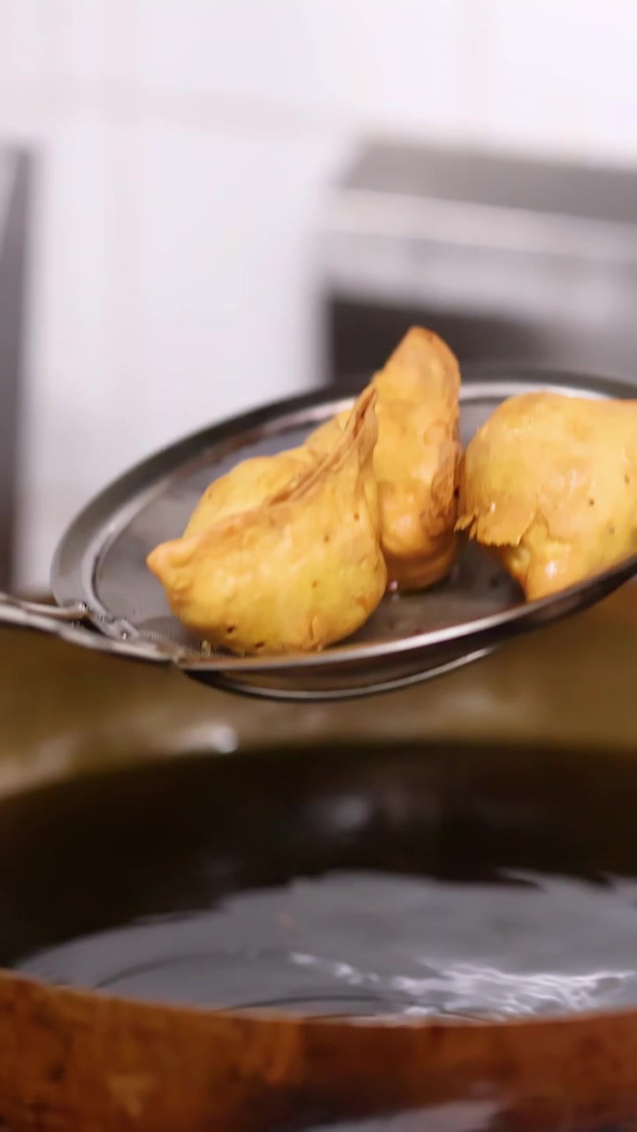 Frittura di samosa in un grande wok di metallo