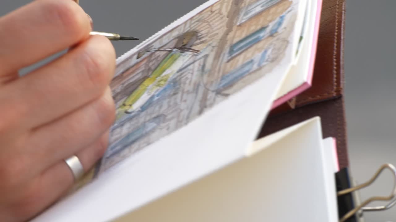 An artist painting with water colours outdoors closer shot 2