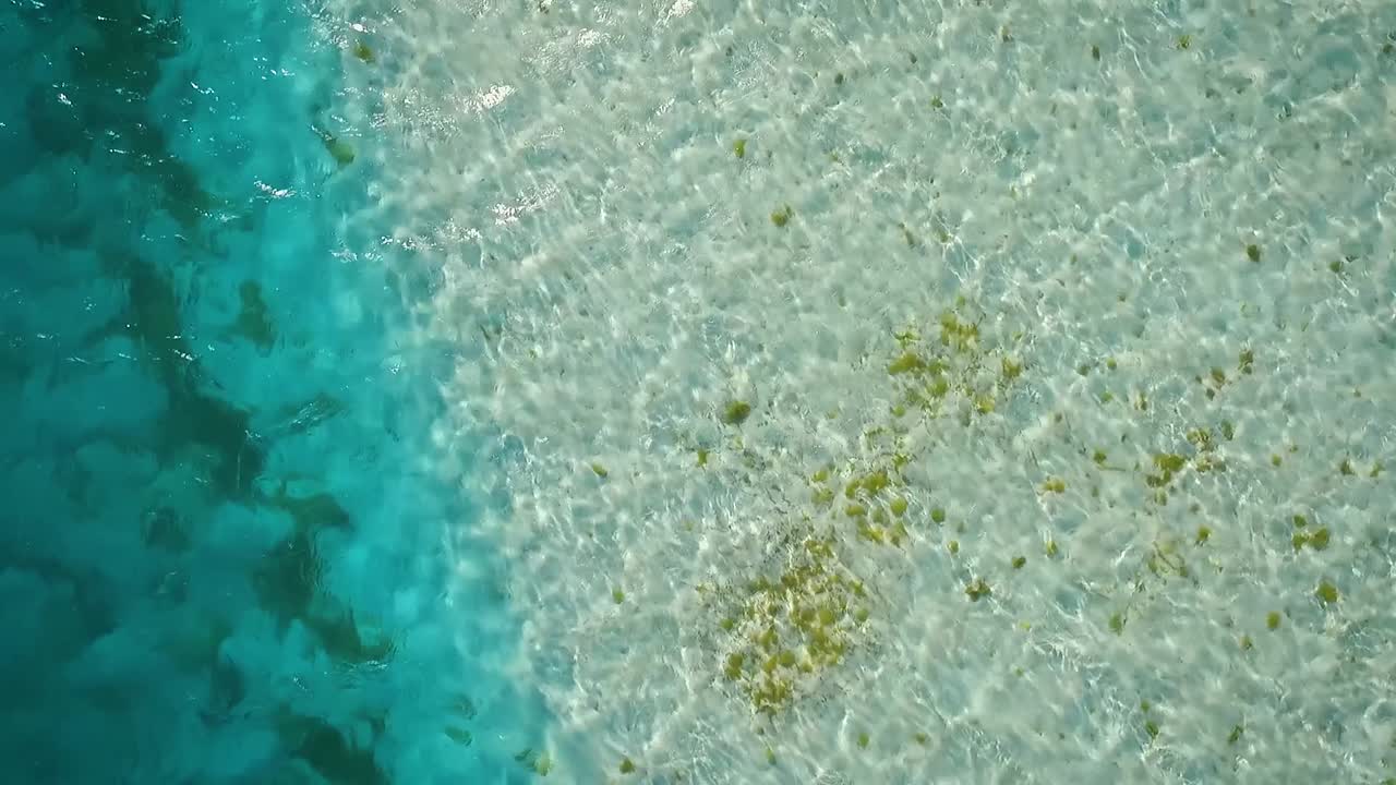 Drone video flying low over a clear Caribbean sea, in Los Roques, Venezuela