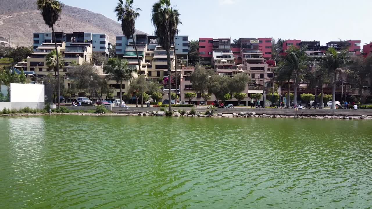 toma de drones de colinas y apartamentos en un lago en la ciudad de lima perú
