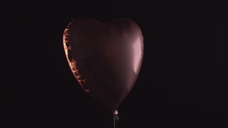 Rising-shape-of-heart-balloon-isolated-on-black-background