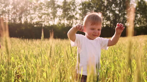 boy in white shirt walking in a field directly into the camera and smiling in a field of spikes