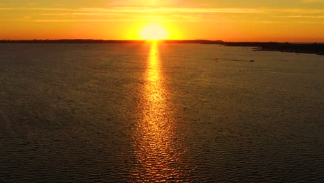 luftaufnahme: kitesurfer schwimmen bei sonnenuntergang mit hoher geschwindigkeit im offenen meer