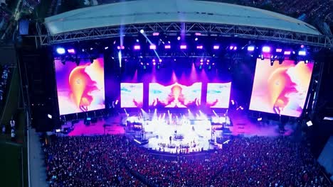 large crowd at a concert with a stage and lights