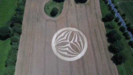 descending aerial view above warminster crop circle 2023, mysterious symmetrical alien pattern on harvested corn field in england