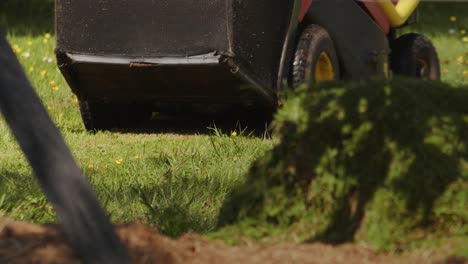 low angle view of ride on lawn mower mowing yard