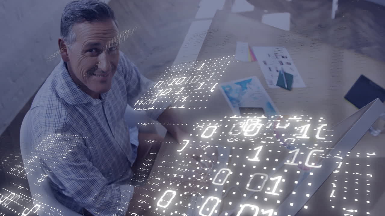 IT professional man typing on keyboard at office desk, with binary code overlay and floating charts