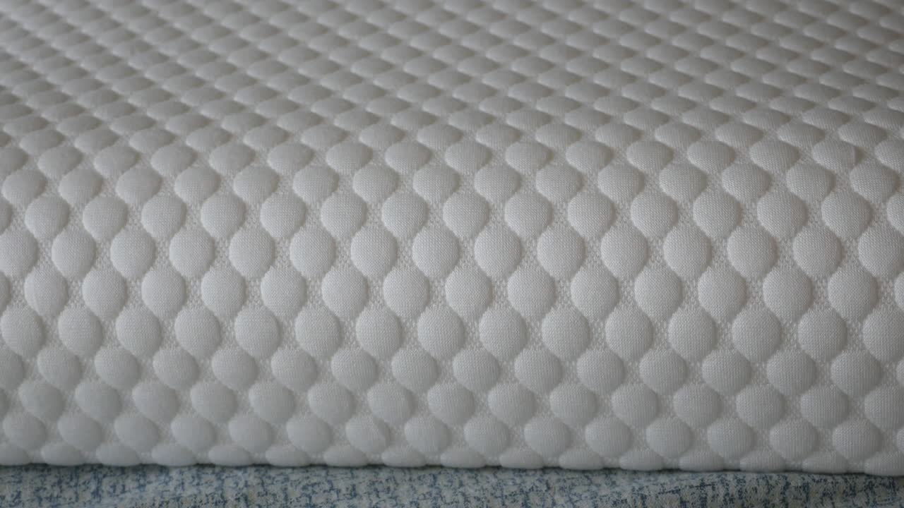 Close-up of a white quilted mattress or fabric texture
