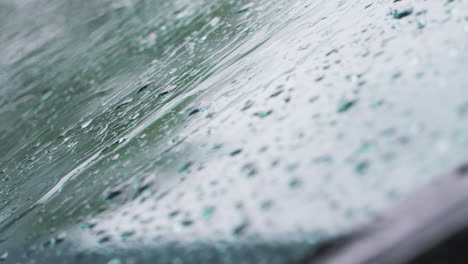 macro close up shot of raindrops falling on car windshield