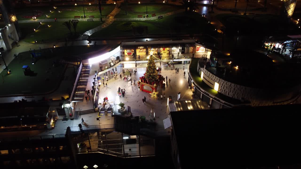 un árbol de navidad iluminado por la noche en un centro comercial