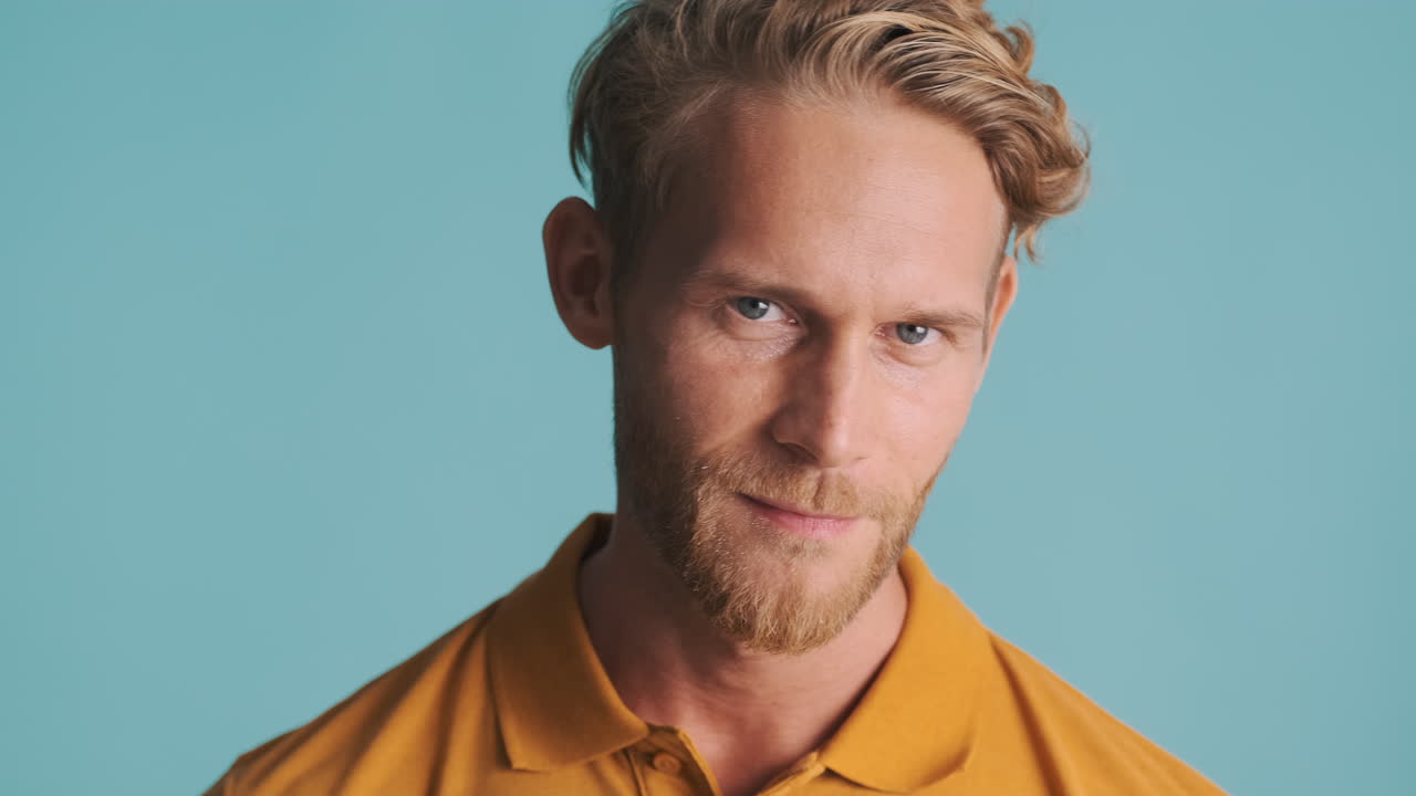 잘생긴 남자가 으로 쳐다보고 포즈를 취하고 있습니다.