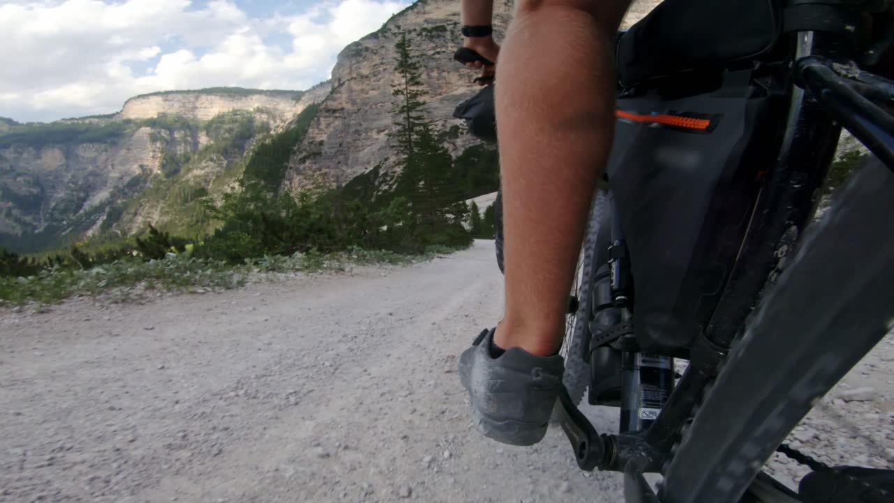 Bikepacking descent on rugged road, moves smoothly, Italy mountain scenery, 4K