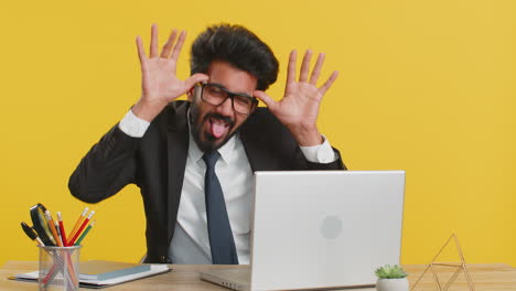 Office-businessman-hiding-behind-laptop-computer-making-funny-silly-face-fooling-around,-disrespect