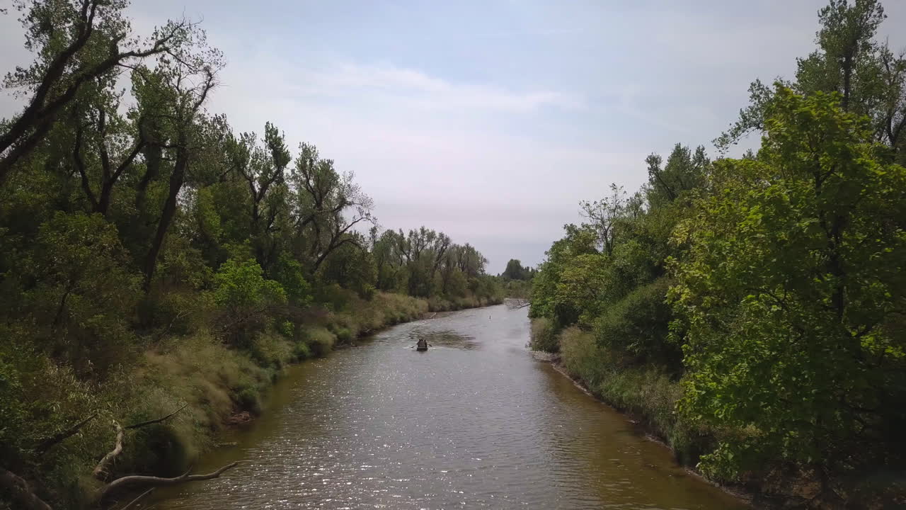 gente haciendo kayak en un tranquilo río de aguas tranquilas, explorando la naturaleza salvaje