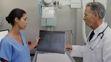 Surgeon-and-colleague-discussing-over-an-x-ray