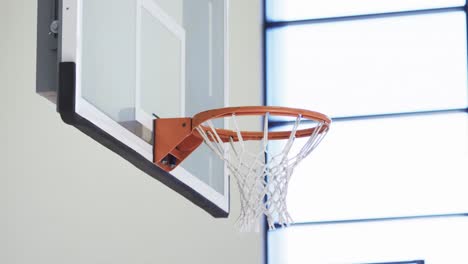 Basketball-bouncing-out-of-basket-during-team-training-game-at-indoor-court,-slow-motion