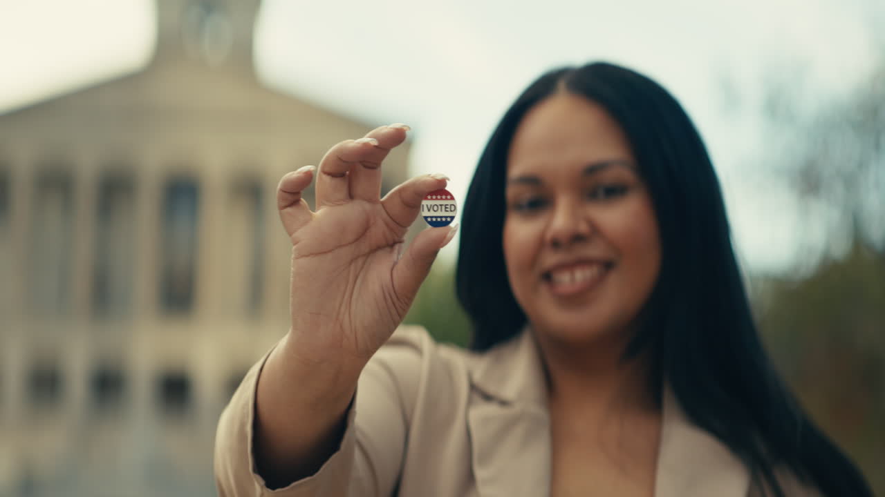 Woman holding an I Voted sticker
