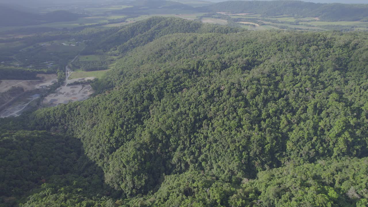 volando sobre exuberantes colinas verdes en port douglas, extremo norte de queensland, australia - toma aérea de drones