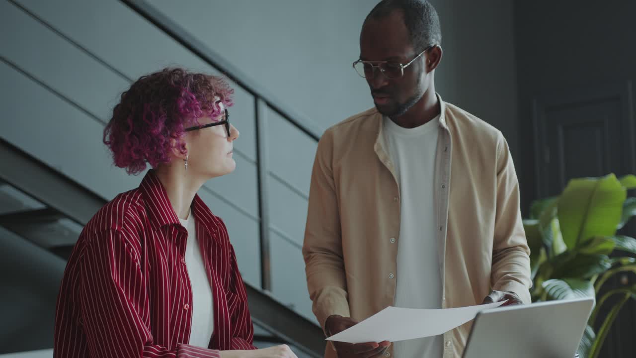 Girl with Prosthetic Arm Discussing Business Plan with Colleague in Office