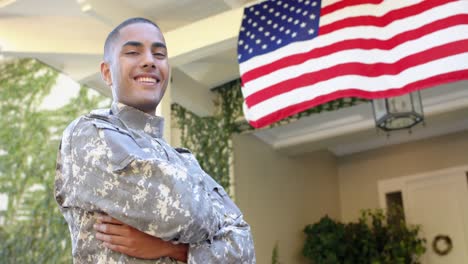 Portrait-of-happy-biracial-male-soldier-in-garden-over-american-flag