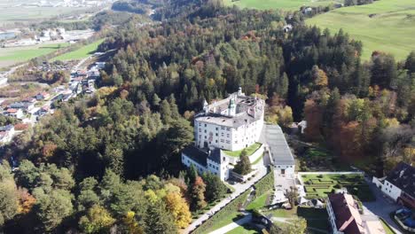 ambras castle in a vertical aerial view on an autumn day and with its green forests and the tranquility of this place in tyrol in austria