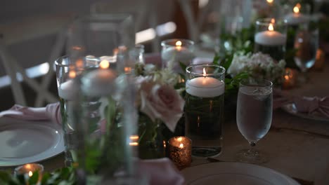 Mesa-Larga-Bellamente-Arreglada-Para-Una-Recepción-De-Boda,-Adornada-Con-Delicadas-Velas,-Flores-Frescas-Y-Todos-Los-Detalles-Que-Contribuyen-A-Un-Ambiente-Romántico-Y-Elegante.