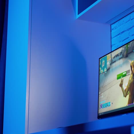 teen boy plays online game on computer at night. side view of a gamer playing a video game in the room. teenager becomes angry after losing in computer game.