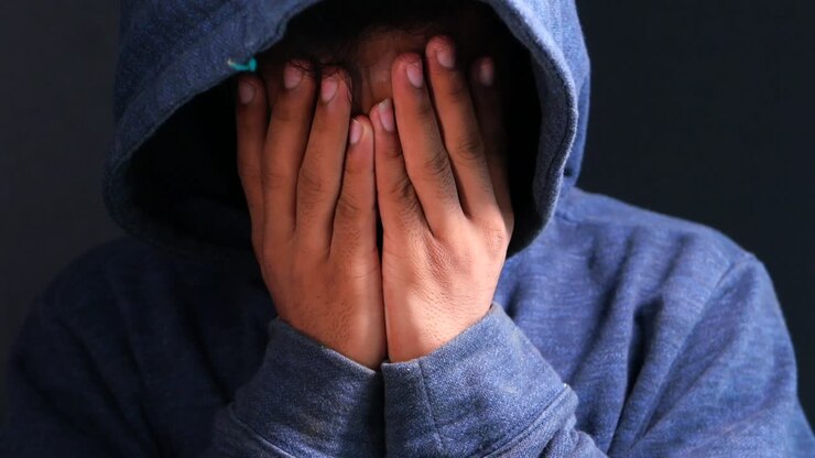 Una persona che si copre il viso con le mani