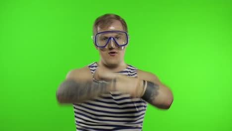 emotional man tourist in underwater mask, striped sailor shirt dances celebrates