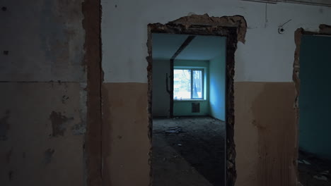entering the doorway in the old building under the demolition process. empty room with two windows.