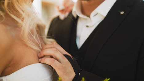 Gentle-groom-strokes-chest-of-beloved-woman-on-street