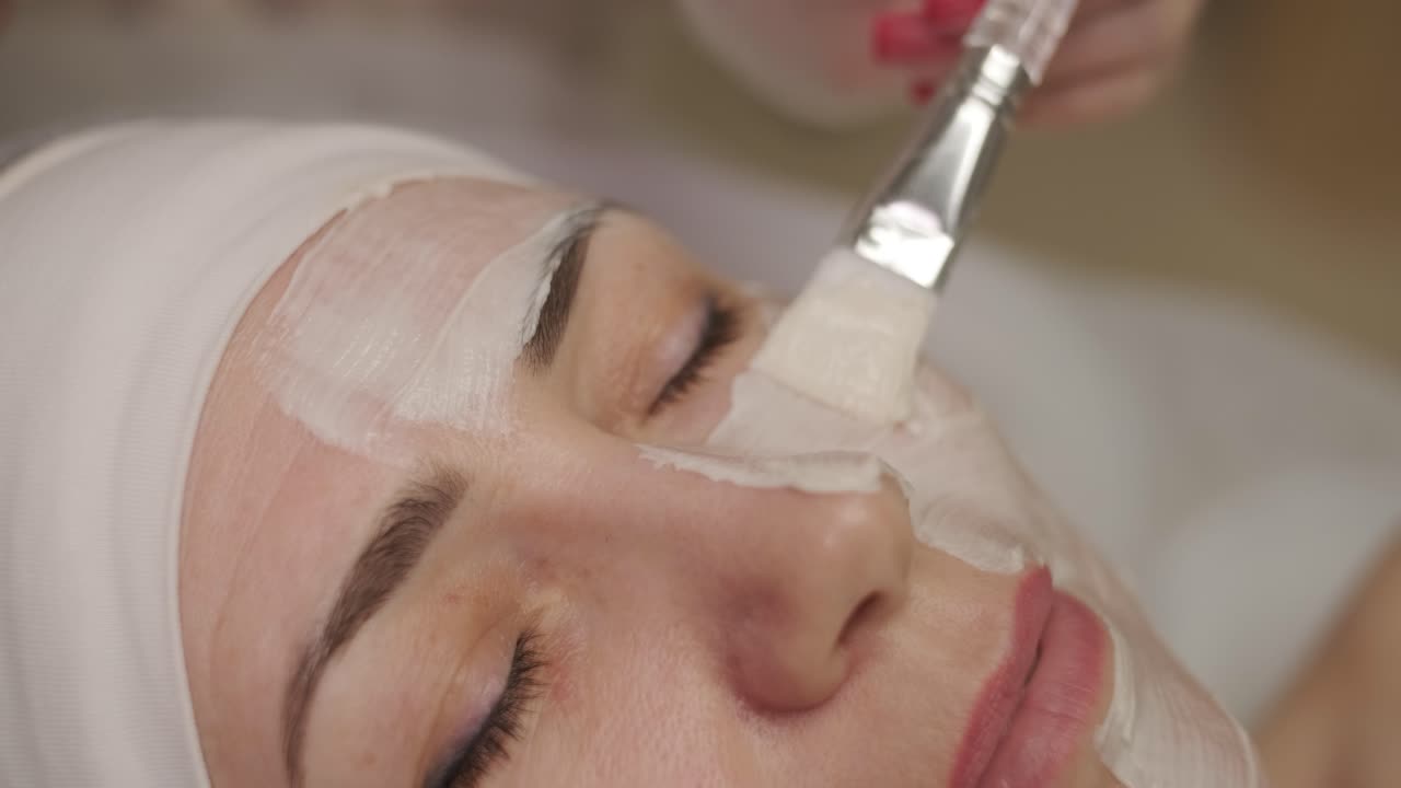Bella donna con maschera facciale al salone di bellezza