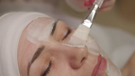 beautiful woman with facial mask at beauty salon