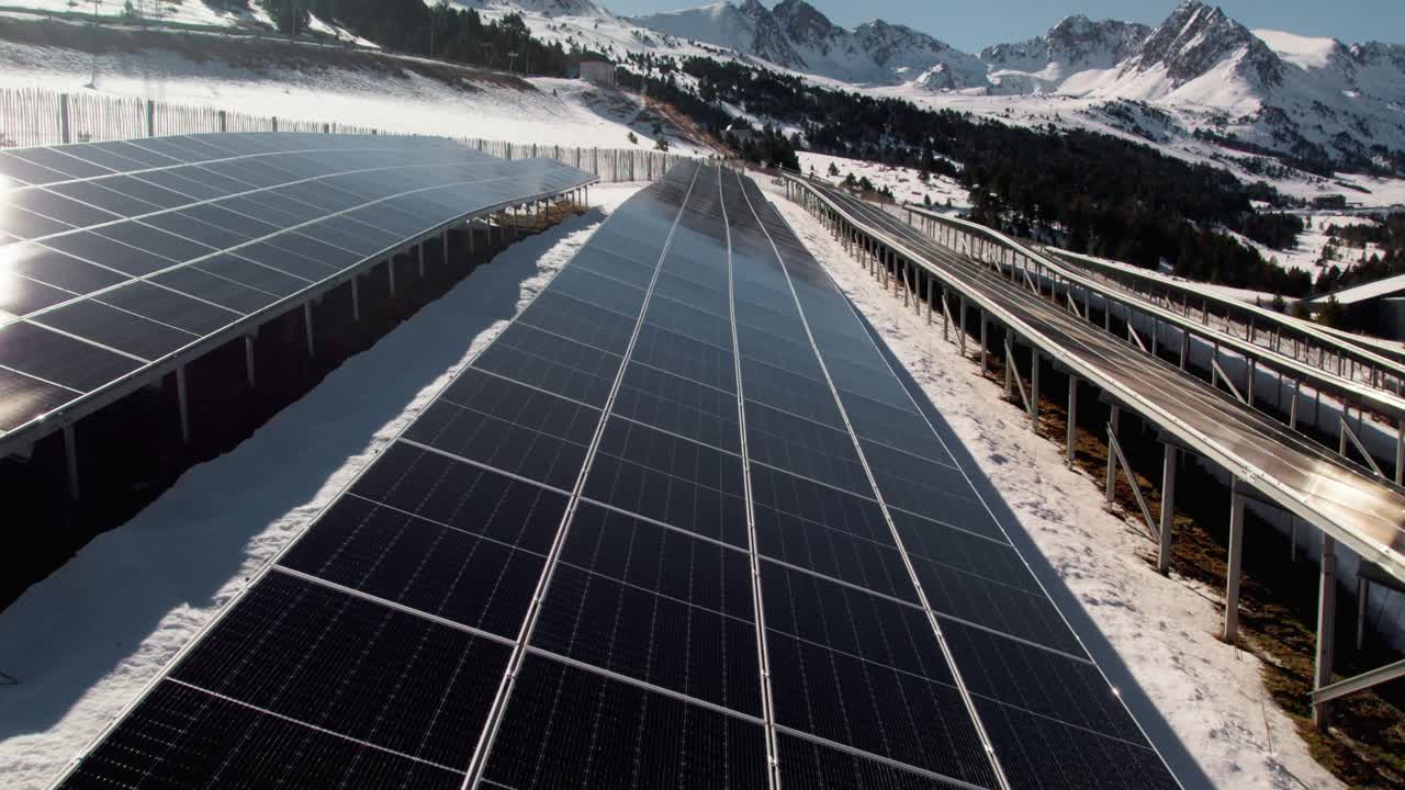 Solar panels close up aerial, winter mountain landscape tilt up revealing
