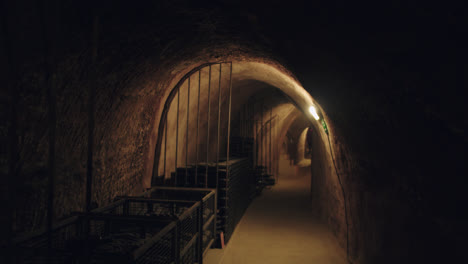 general shot of a dimly lit underground wine cellar in burgos, spain with los light