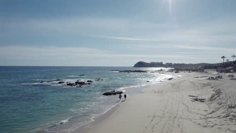 Dos-Personas-Caminan-En-La-Playa-De-Cabo-San-Lucas-En-México,-Baja-California