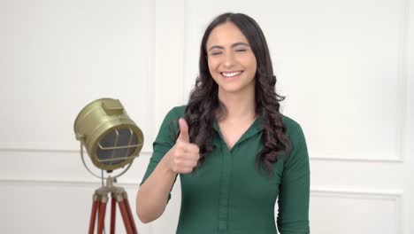 chica india mostrando los pulgares hacia arriba