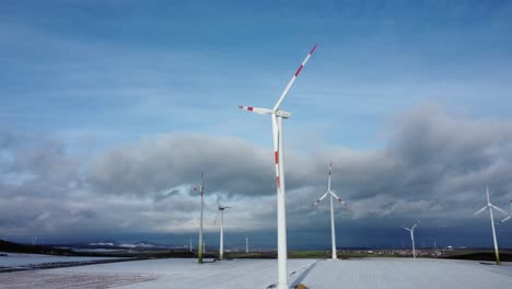 antena de órbita de ángulo bajo de la granja de turbinas eólicas eléctricas, energía alternativa limpia con nieve de invierno durante el día soleado