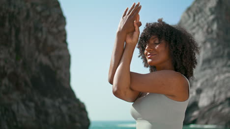 Yogi-Mädchen-Kreuzt-Die-Hände-Vor-Dem-Gesicht-Und-Trainiert-Am-Ursa-Beach-Vertikal-Aus-Nächster-Nähe