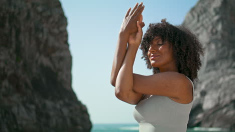 yogi girl crossing hands in front face training on ursa beach vertical close up
