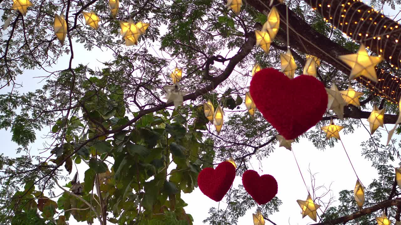 많은 종이 별과 밤에 반이는 불빛으로 나무에 매달린 은 심장 발렌타인 데이 개념